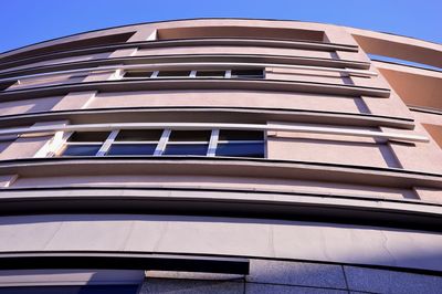 Low angle view of modern building against blue sky