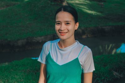 Portrait of young woman standing on field