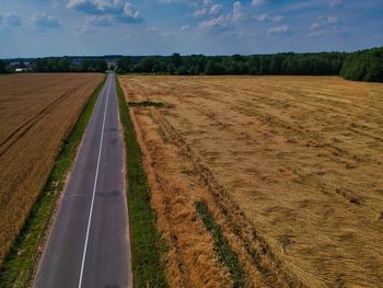 Road amidst field against sky