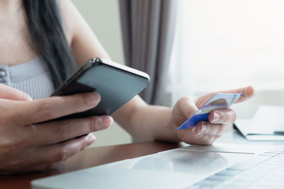 Midsection of man using mobile phone