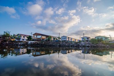 Reflection of buildings in lake against sky