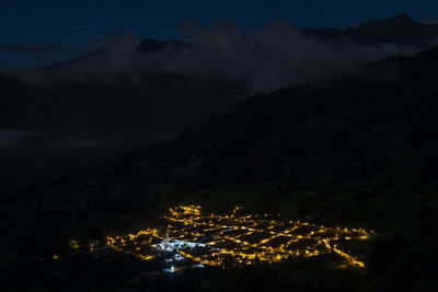 High angle view of illuminated mountains against sky at night