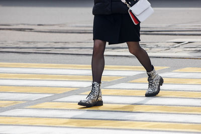 Low section of woman walking on zebra crossing