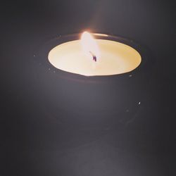 Burning candle in dark room