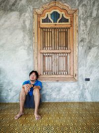 Full length portrait of a man sitting on floor