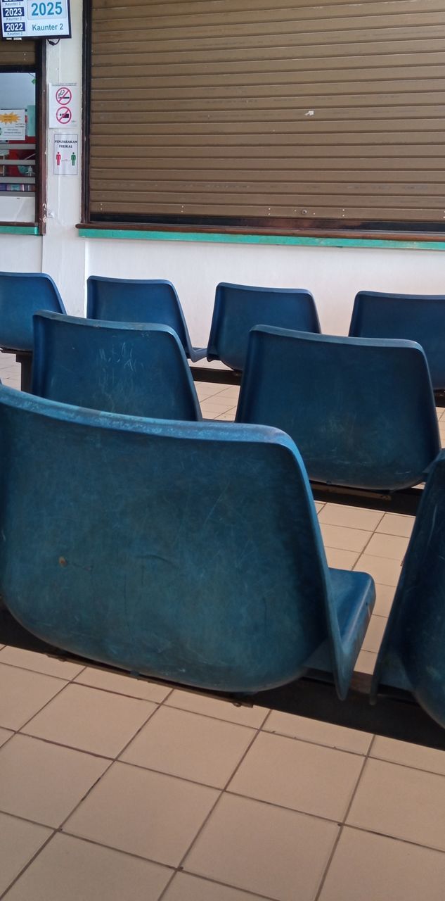 EMPTY CHAIRS AND TABLE BY WALL