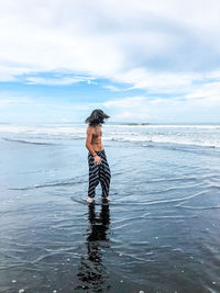 Man standing on beach against sky