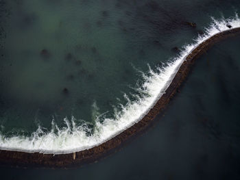 Close-up of wave splashing on sea against sky at night