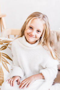 Portrait of smiling girl sitting at home