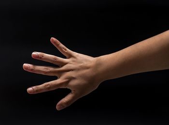 Close-up of human hand against black background