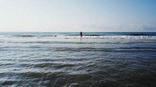 Man standing on beach against clear sky