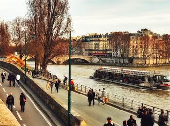 People on bridge over river in city