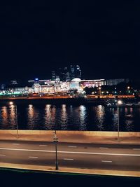 Illuminated cityscape against sky at night