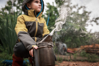 Full length of boy holding fog machine on land