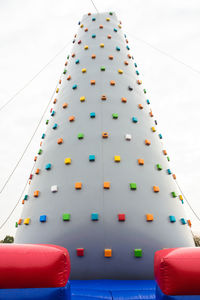 Low angle view of climbing wall against sky