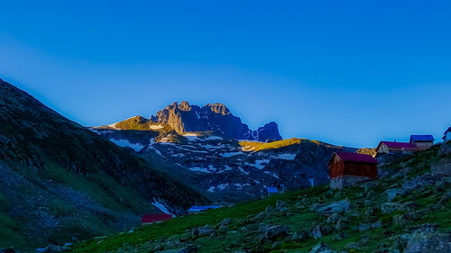 Scenic view of snowcapped mountains against clear blue sky