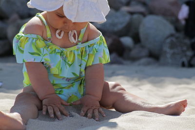 Rear view of boy sitting at beach