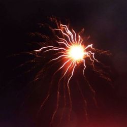 Low angle view of firework display at night