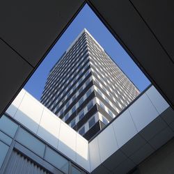 Low angle view of office building against clear blue sky