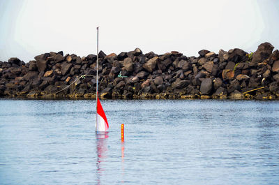 Sailboat on rock by sea against sky