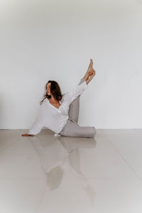 Portrait of young woman standing against wall