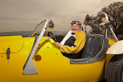 Portrait of smiling man sitting on yellow cart