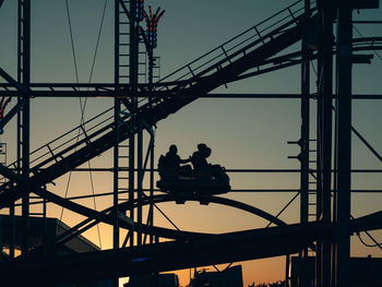 Silhouette people working on bridge against sky