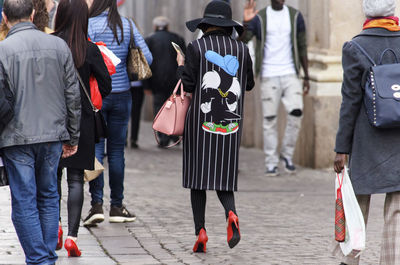 Low section of people standing on tiled floor