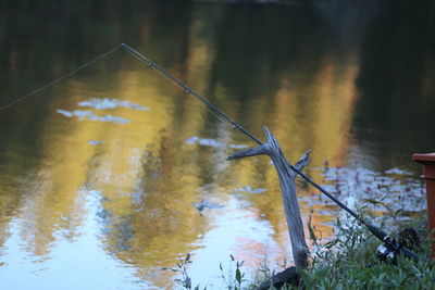 High angle view of fishing rod leaning on stick over river