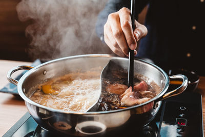 Midsection of person preparing food in kitchen