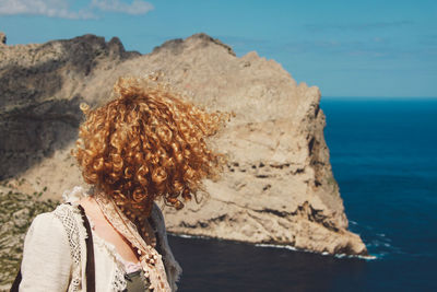 Mid adult woman standing against sea