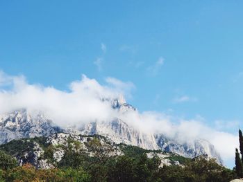 Smoke emitting from mountain against sky