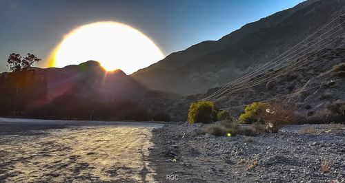 Scenic view of mountains against bright sun