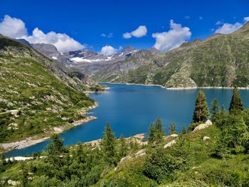 Scenic view of lake and mountains against blue sky