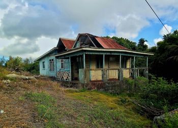 Abandoned house on field against sky