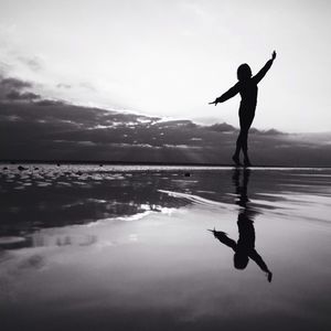 Silhouette woman exercising on beach