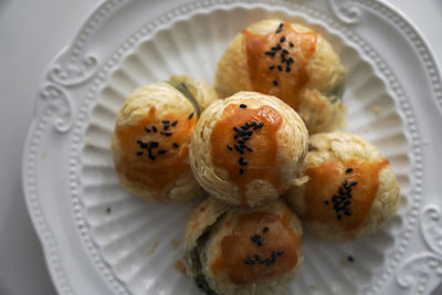 There are some delicious black sesame egg yolk pastries freshly baked on the plate on the table