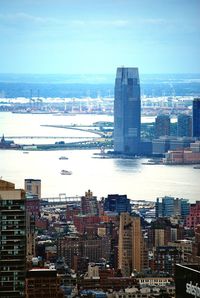 Modern buildings by sea against sky in city