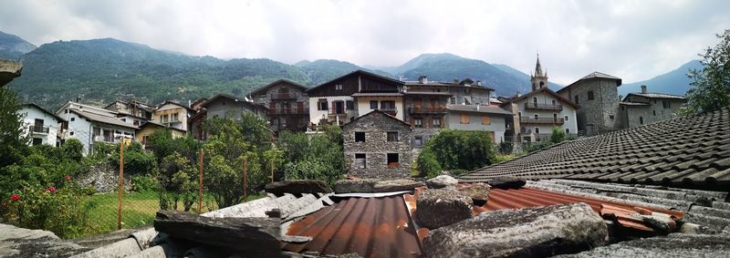 Panoramic view of buildings against cloudy sky