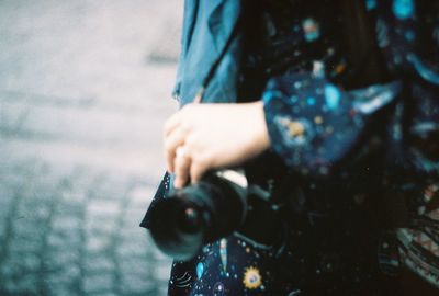 Midsection of woman photographing at camera