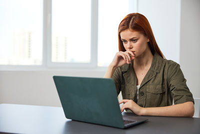 Businesswoman using laptop at office