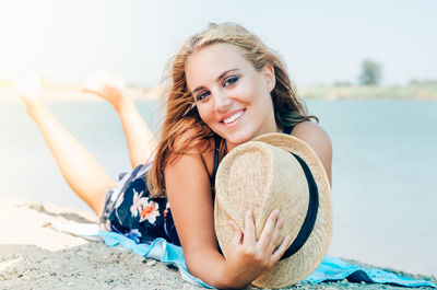 Portrait of smiling young woman relaxing at beach