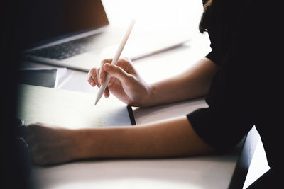 Midsection of woman working at table