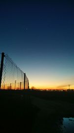 Silhouette field against clear sky during sunset