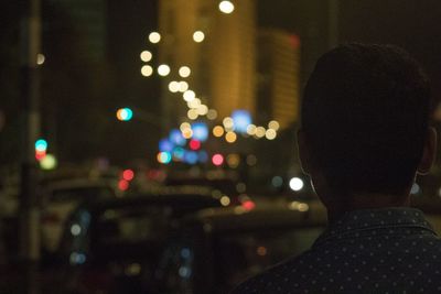 Rear view of man in city street at night