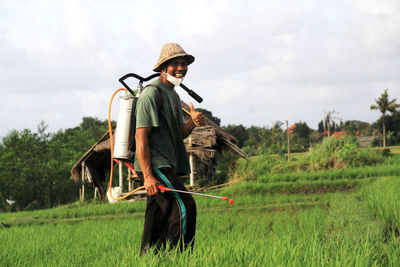 Side view of young woman standing on field