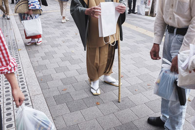 Low section of man standing on sidewalk