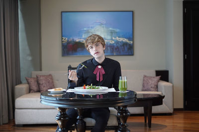 Full length of boy sitting at table at home