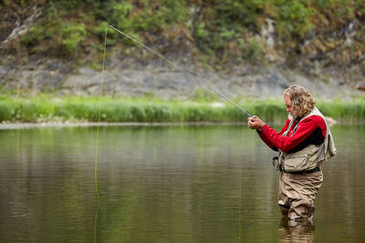 Side view of a man fishing in lake