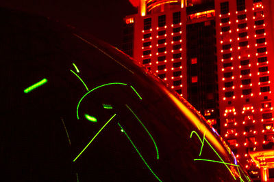 Low angle view of illuminated street light against building at night